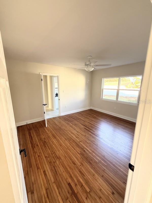 spare room featuring dark hardwood / wood-style floors and ceiling fan