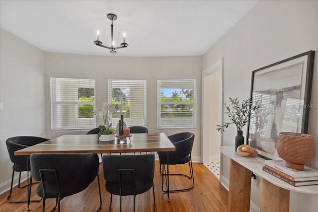 dining area featuring light hardwood / wood-style flooring and a chandelier