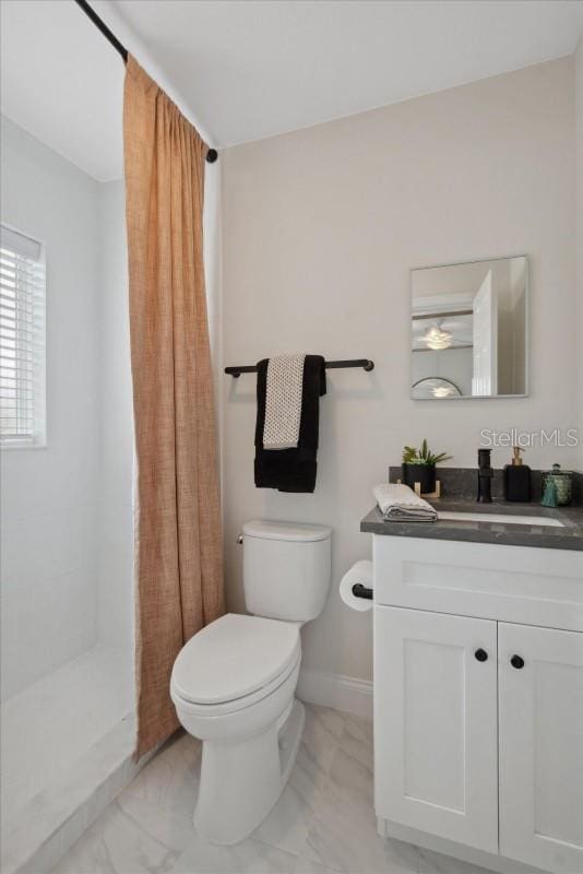 bathroom featuring a shower with curtain, vanity, and toilet