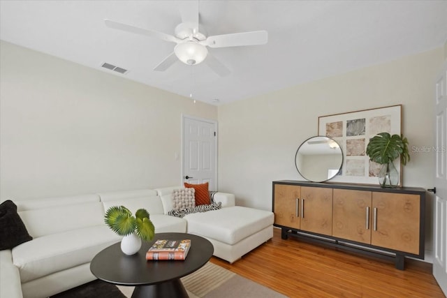 living room with ceiling fan and light hardwood / wood-style flooring