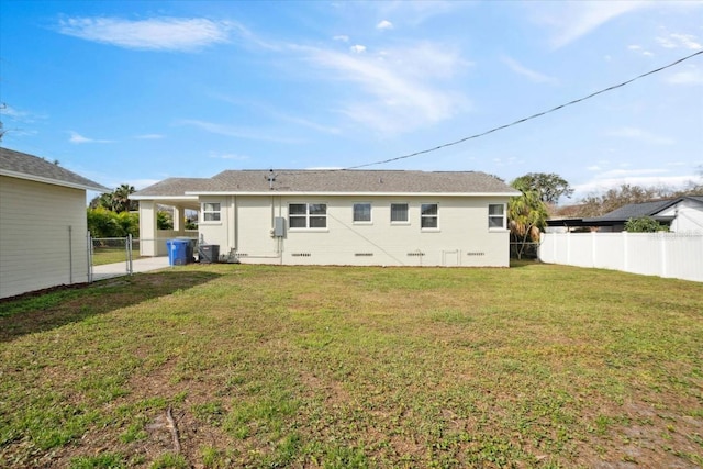 rear view of house with a yard and central AC unit