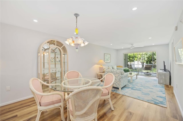 dining room featuring light hardwood / wood-style floors and ceiling fan with notable chandelier