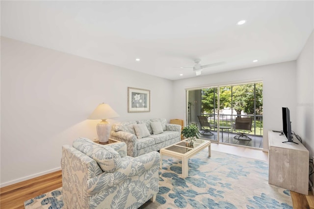 living room featuring light hardwood / wood-style flooring and ceiling fan