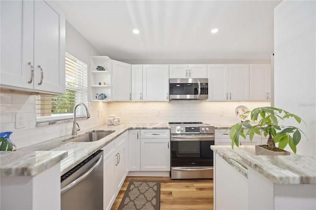 kitchen featuring light stone counters, white cabinetry, sink, and appliances with stainless steel finishes