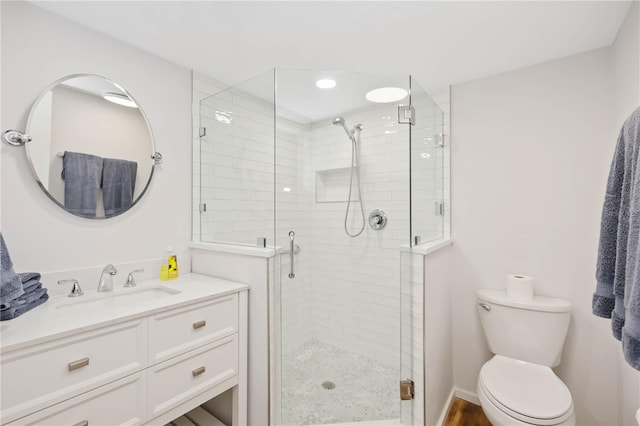 bathroom featuring vanity, toilet, and a shower with door