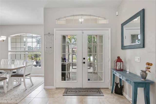 entryway with light tile patterned flooring and french doors