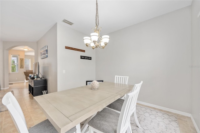 tiled dining room featuring a notable chandelier