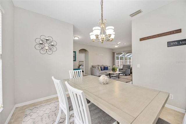 tiled dining room featuring a notable chandelier