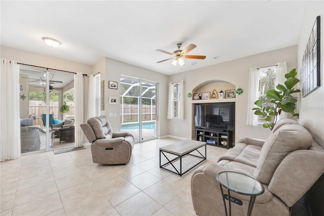 living room with light tile patterned floors, plenty of natural light, and ceiling fan