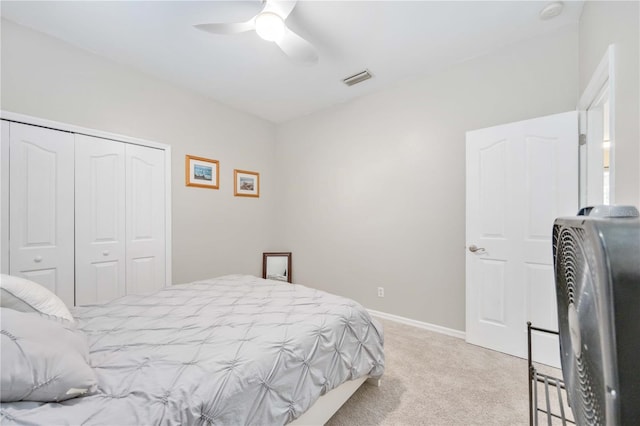 carpeted bedroom featuring ceiling fan and a closet