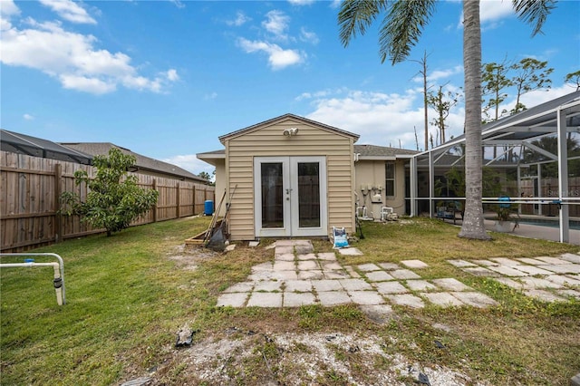 view of outdoor structure with a swimming pool, a yard, and french doors