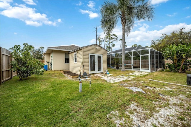 back of house featuring a lanai, a lawn, and french doors