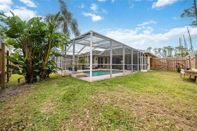 rear view of house featuring a fenced in pool, glass enclosure, and a lawn