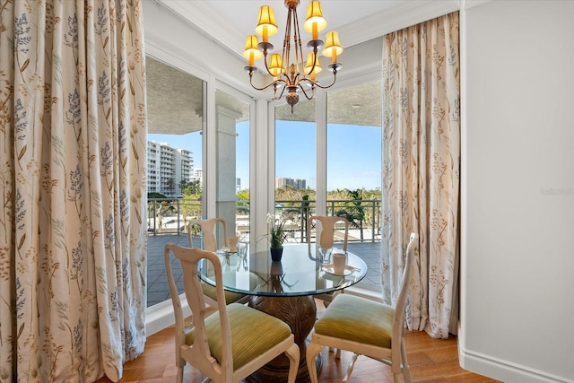 dining area with ornamental molding, light hardwood / wood-style flooring, and a chandelier