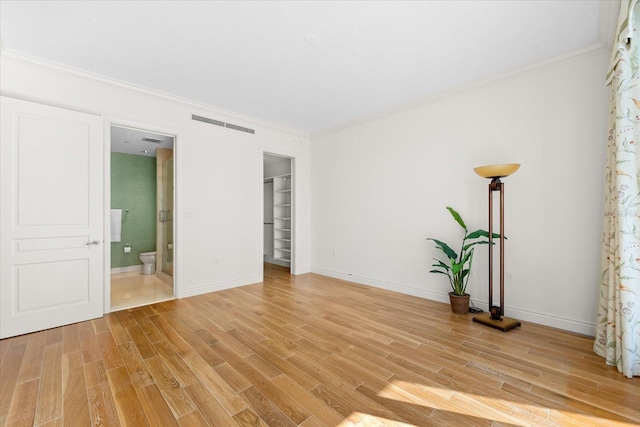 empty room featuring crown molding and light hardwood / wood-style flooring