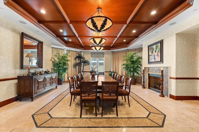 dining space featuring beam ceiling, a tiled fireplace, crown molding, and coffered ceiling