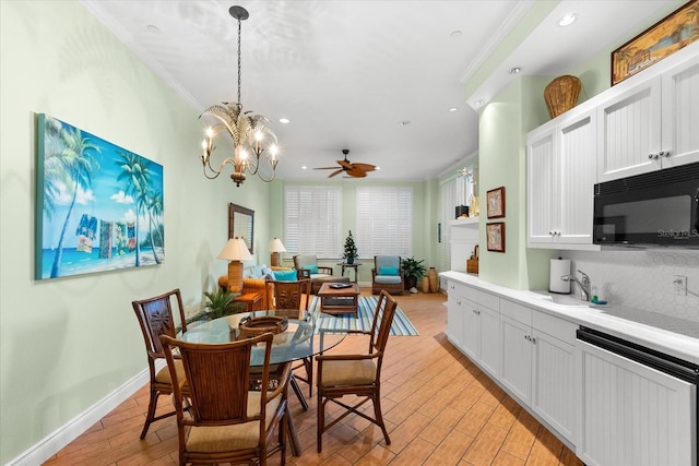 dining space featuring ceiling fan with notable chandelier, ornamental molding, and sink