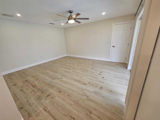 spare room with a textured ceiling, light hardwood / wood-style floors, and ceiling fan