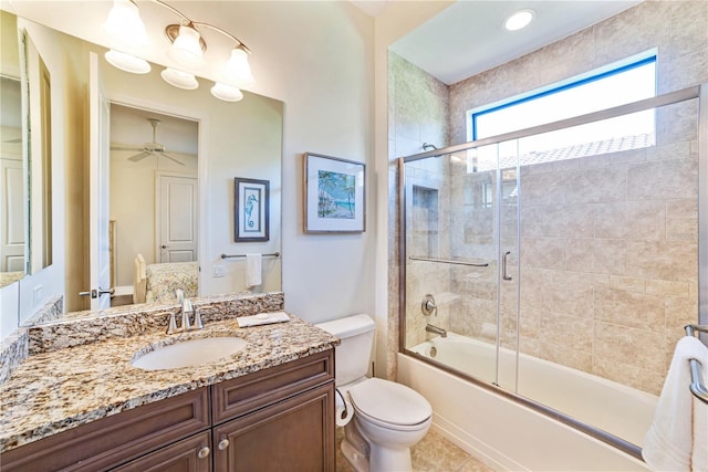 full bathroom featuring ceiling fan, shower / bath combination with glass door, vanity, and toilet