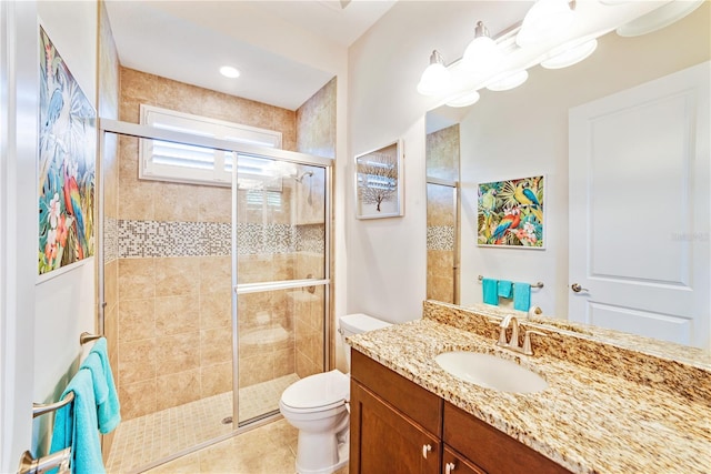 bathroom with toilet, tile patterned floors, a shower with shower door, and vanity