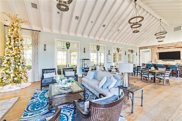 living room featuring french doors, high vaulted ceiling, light wood-type flooring, and beamed ceiling