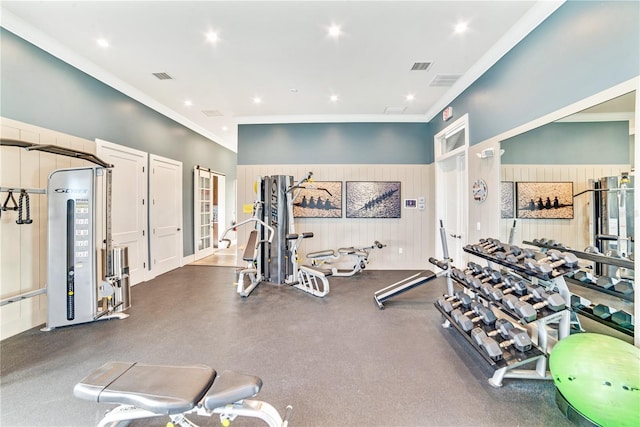 exercise room with crown molding and wood walls