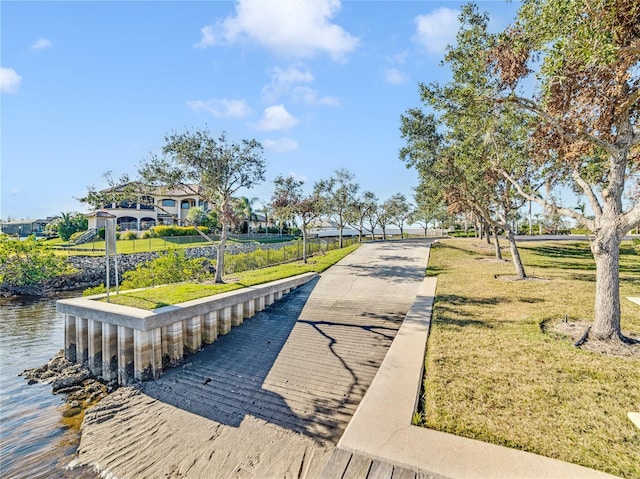 view of property's community featuring a lawn and a water view