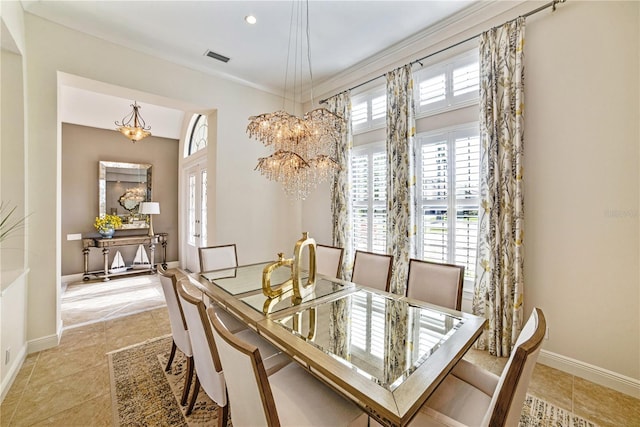 dining area with light tile patterned floors, ornamental molding, a notable chandelier, and baseboards