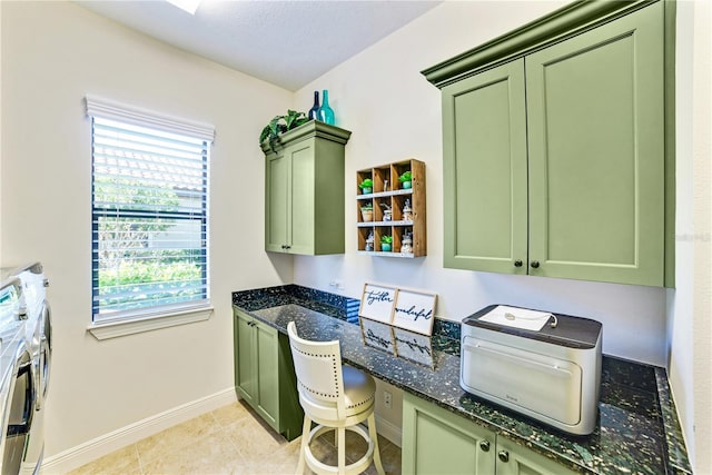 kitchen with built in desk, green cabinetry, and independent washer and dryer