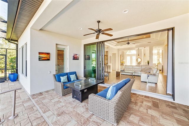 view of patio with a ceiling fan, glass enclosure, and an outdoor living space