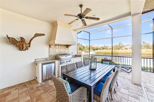 view of patio / terrace with area for grilling, a lanai, a water view, outdoor dining area, and exterior kitchen