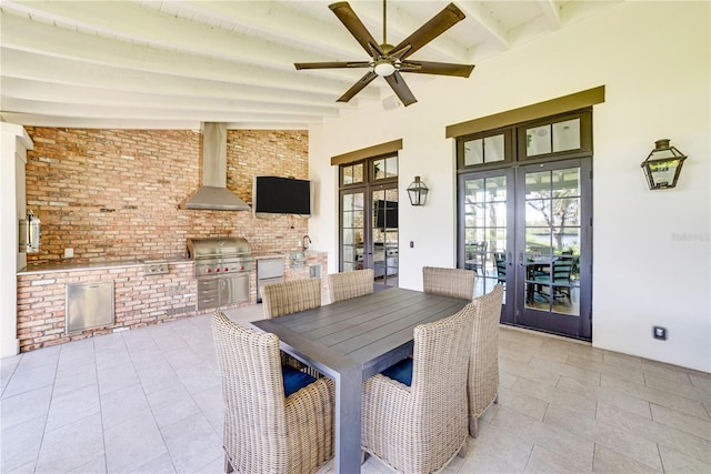 tiled dining area featuring ceiling fan, brick wall, french doors, and beam ceiling