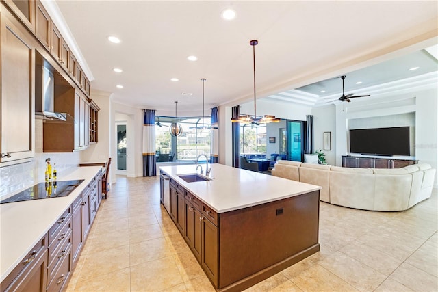 kitchen featuring crown molding, recessed lighting, a sink, an island with sink, and black electric cooktop