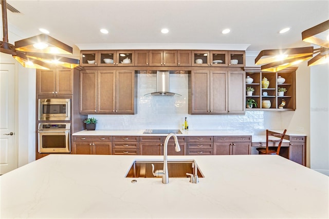 kitchen with open shelves, stainless steel appliances, decorative backsplash, a sink, and wall chimney exhaust hood