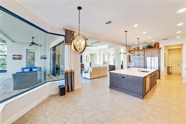 kitchen with crown molding, visible vents, open floor plan, and a sink