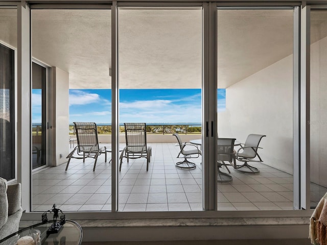 doorway with expansive windows and tile patterned floors