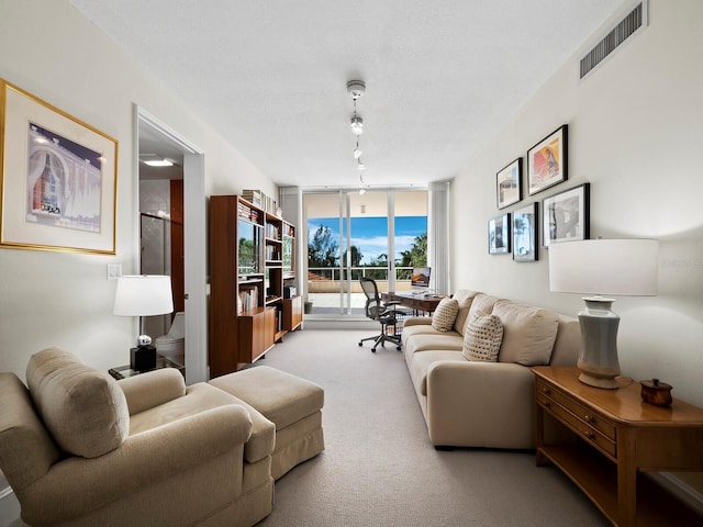 living area featuring a wall of windows, carpet flooring, visible vents, and rail lighting