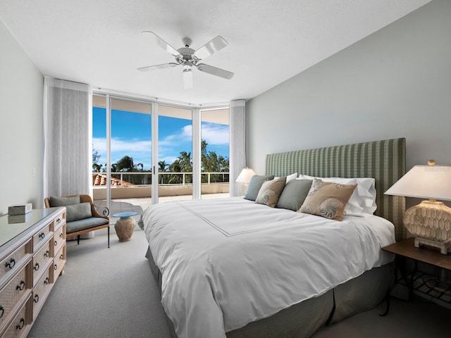 carpeted bedroom featuring expansive windows and ceiling fan