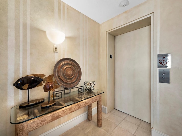 hall with elevator and tile patterned floors