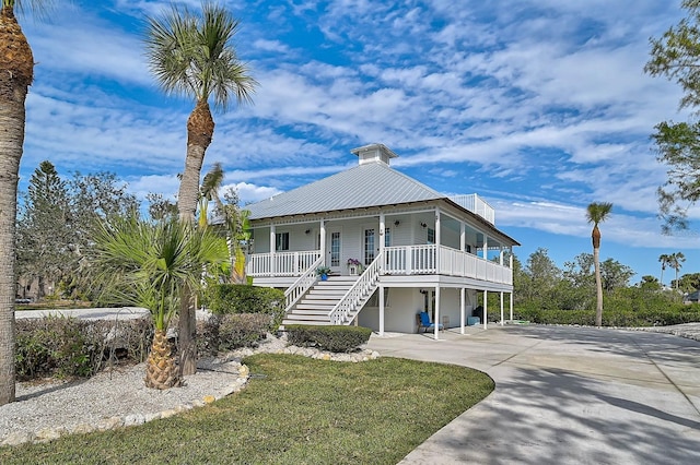 beach home with a front lawn, a carport, and covered porch