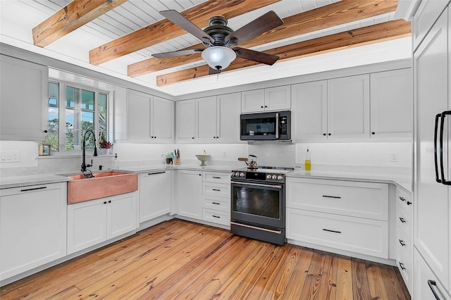 kitchen with light wood-type flooring, electric range oven, beam ceiling, white cabinets, and sink