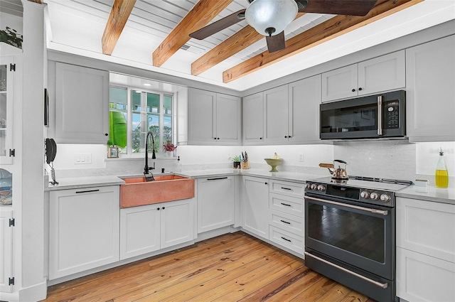 kitchen with ceiling fan, electric range oven, beam ceiling, light hardwood / wood-style flooring, and sink