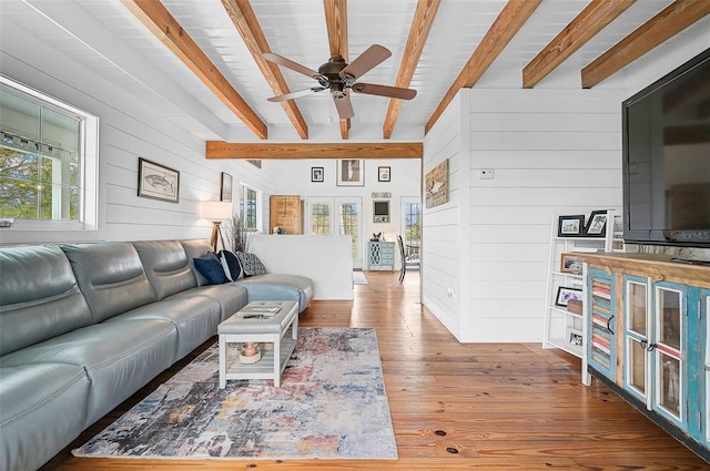 living room with dark hardwood / wood-style flooring, beam ceiling, and wooden walls