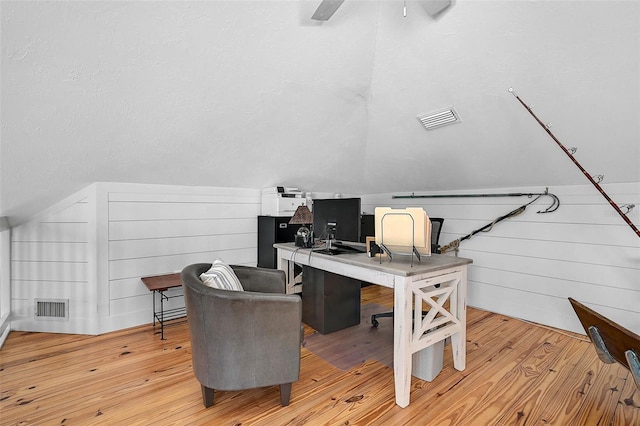 office space featuring ceiling fan, vaulted ceiling, a textured ceiling, and light hardwood / wood-style flooring