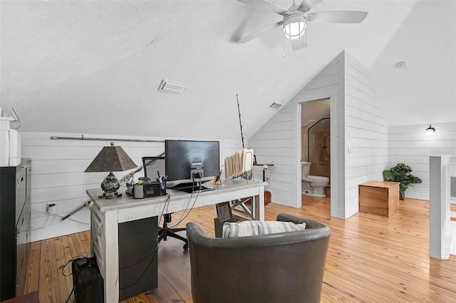 office with lofted ceiling, ceiling fan, wood walls, and hardwood / wood-style flooring