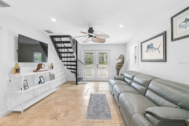 living room featuring ceiling fan, a textured ceiling, and french doors