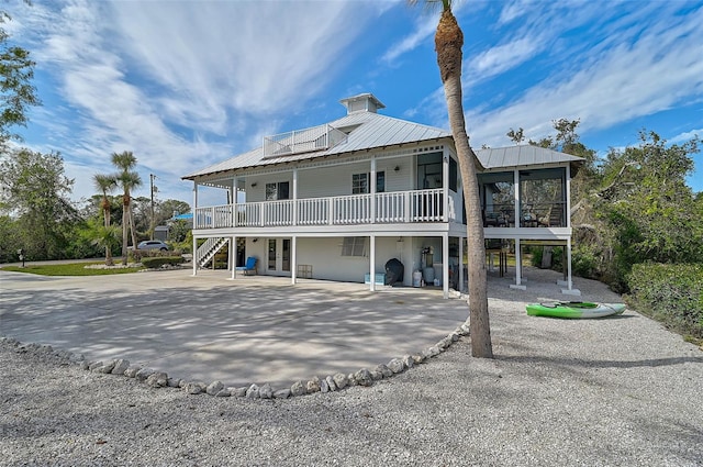 rear view of property featuring a sunroom and french doors