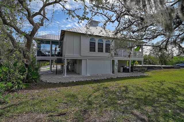 rear view of house with a sunroom, a lawn, and central AC unit