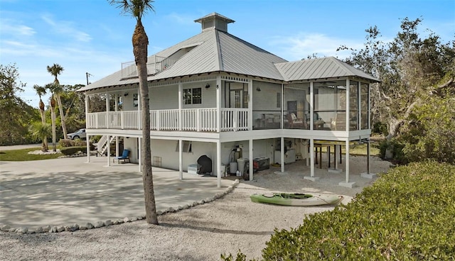 rear view of house featuring a sunroom and a patio