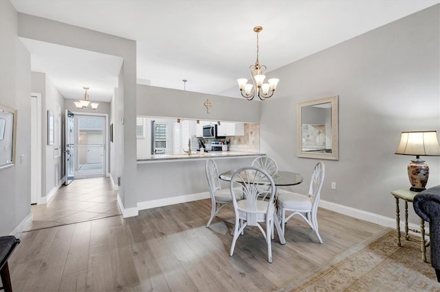 dining area with a chandelier and light wood-type flooring